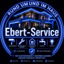 Logo Ebert-Service: leuchtender Schriftzug vor einem Haus bei Nacht